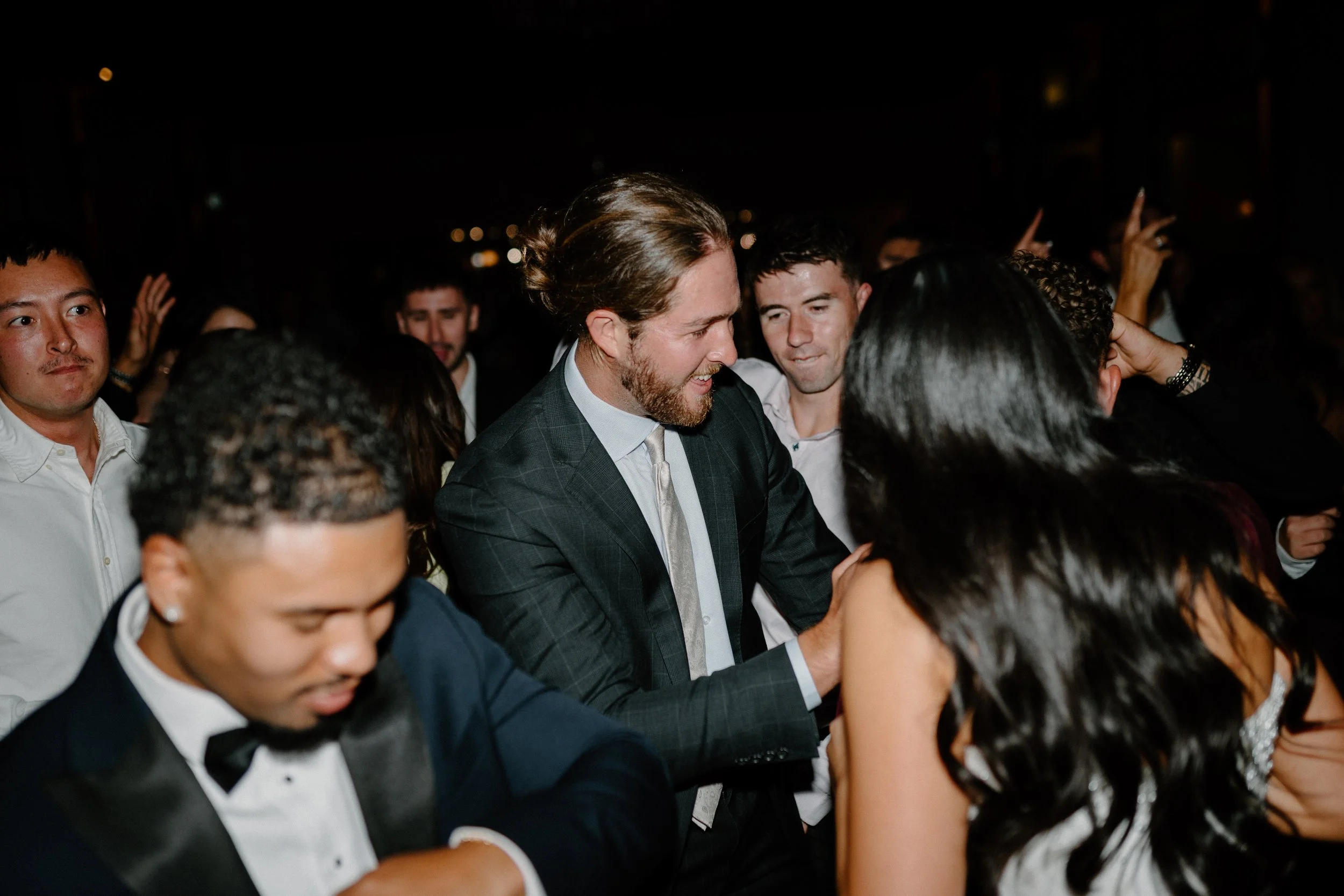 Group of people dancing at a party or celebration at night.