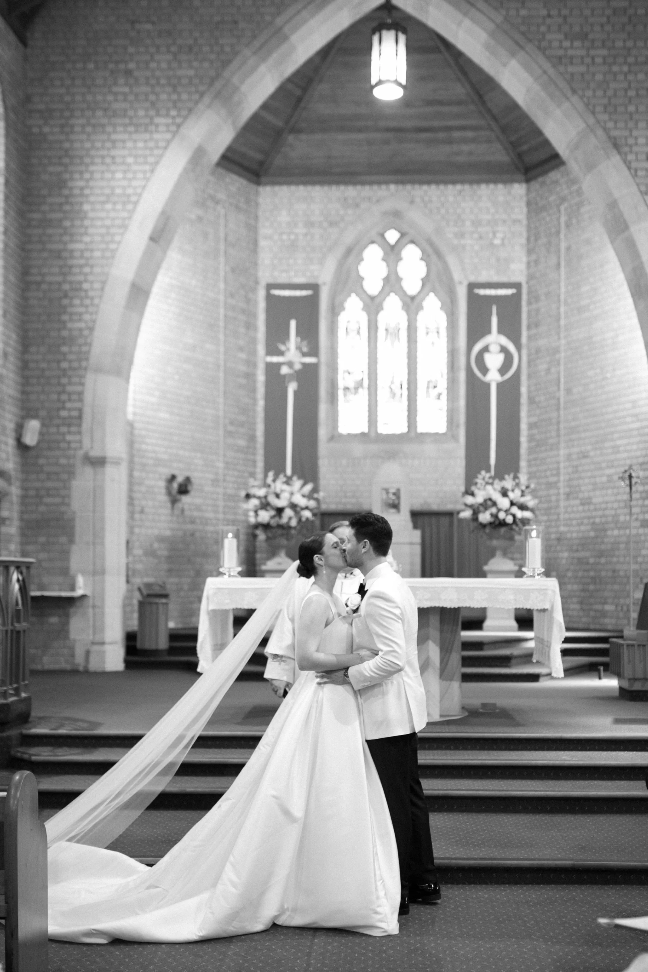 A bride and groom sharing a kiss inside a church during their wedding ceremony.