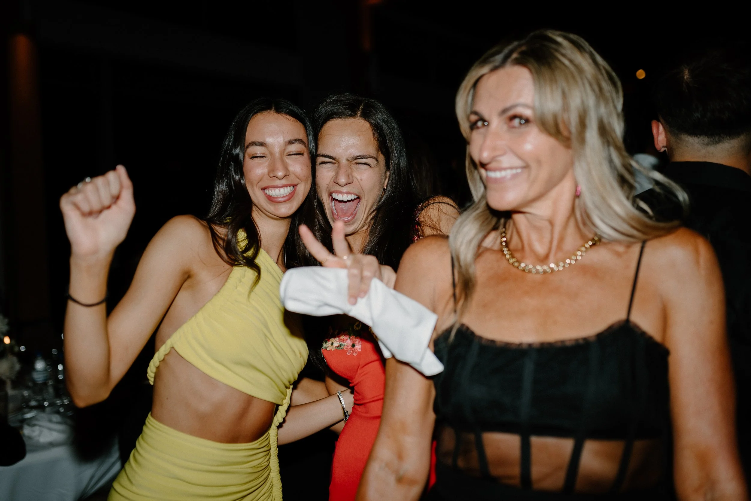Group of women celebrating and having fun at a party or gathering, smiling and dancing.
