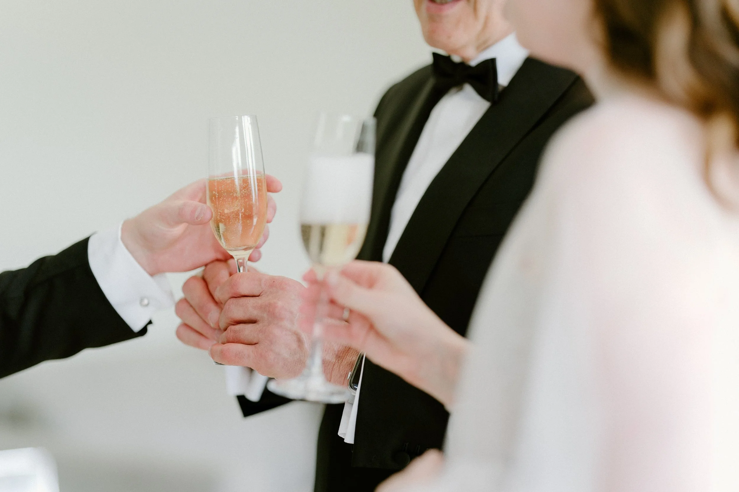 People in wedding attire toasting with champagne glasses during a celebration.
