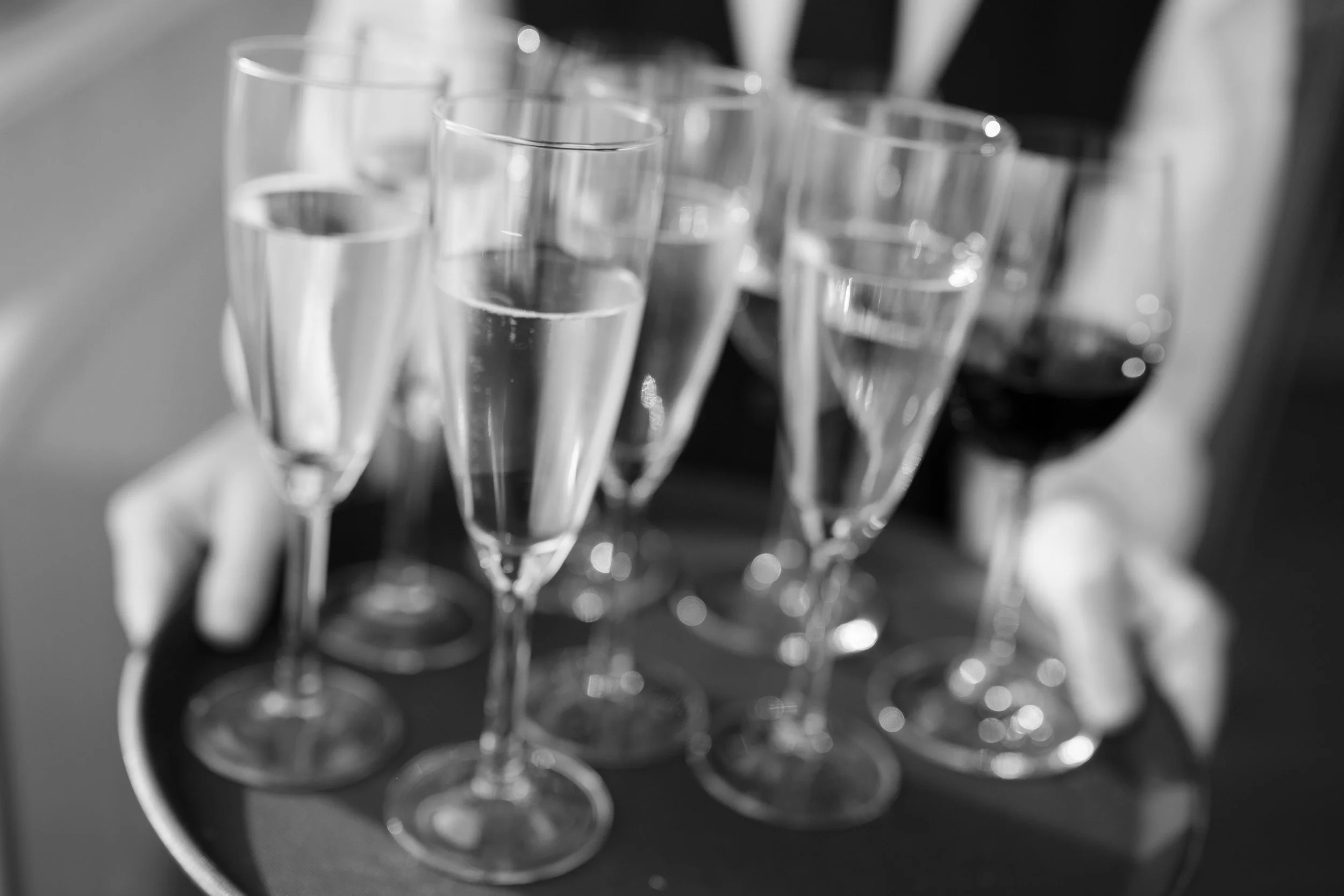 Tray with multiple glasses of champagne and red wine.