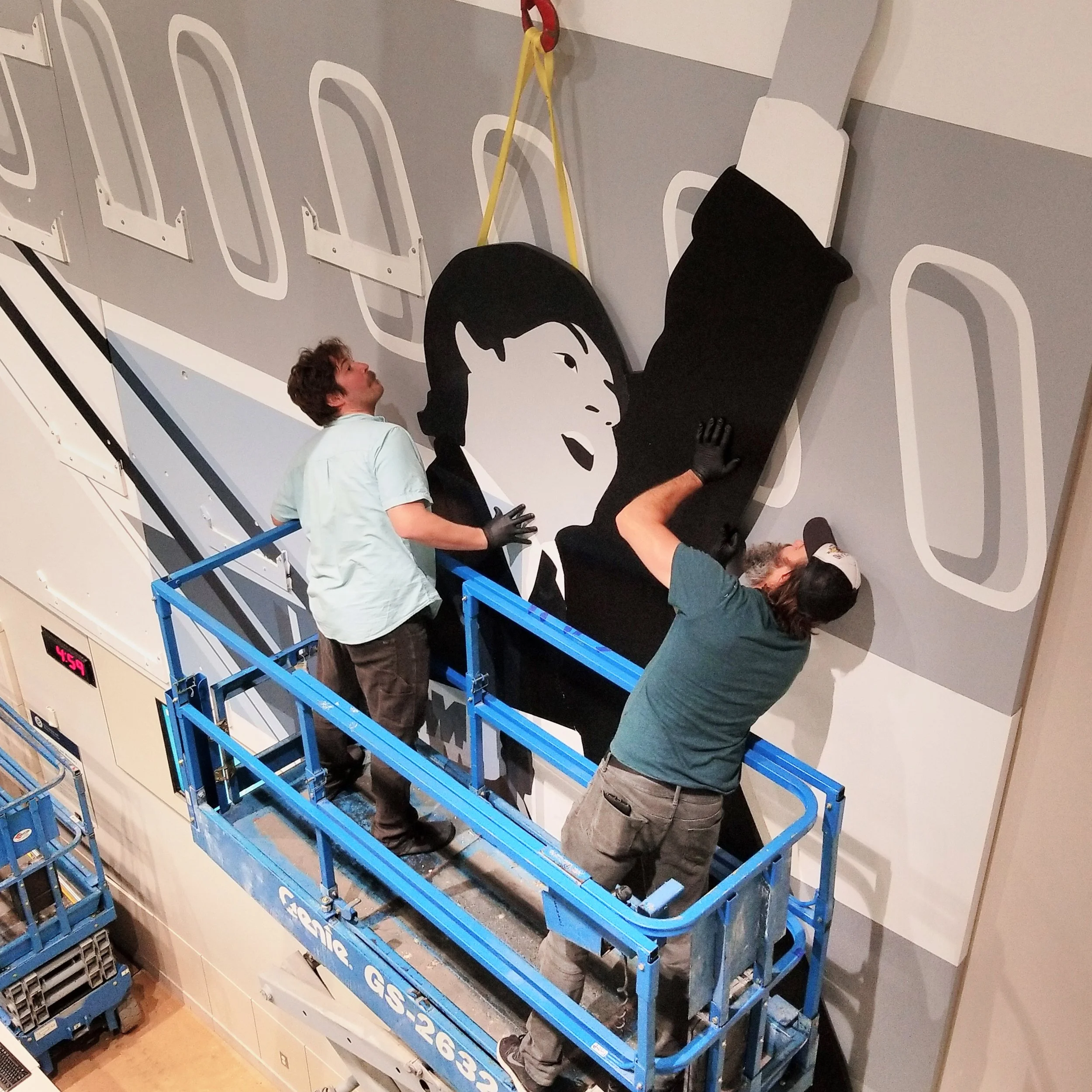 Atthowe art handlers in a lift installing Kota Ezaawa's "Mondrian Meets The Beatles" at SFO International Terminal.