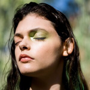 Woman+standing+in+the+sun+with+eyes+closed+and+fun+makeup.jpeg