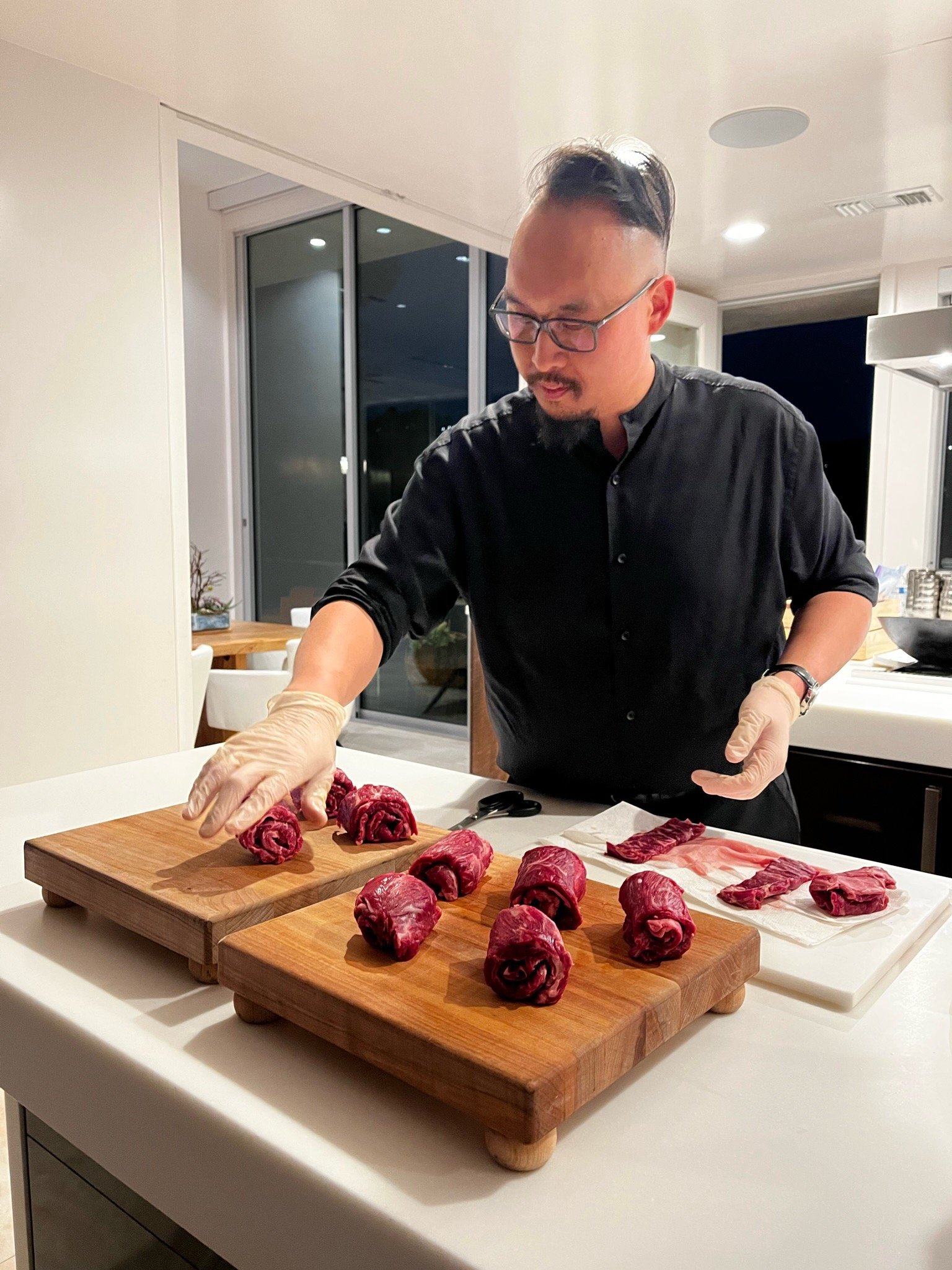 Chef John Bach plating sliced steak for a Korean BBQ tasting experience at a catered event in Southern California