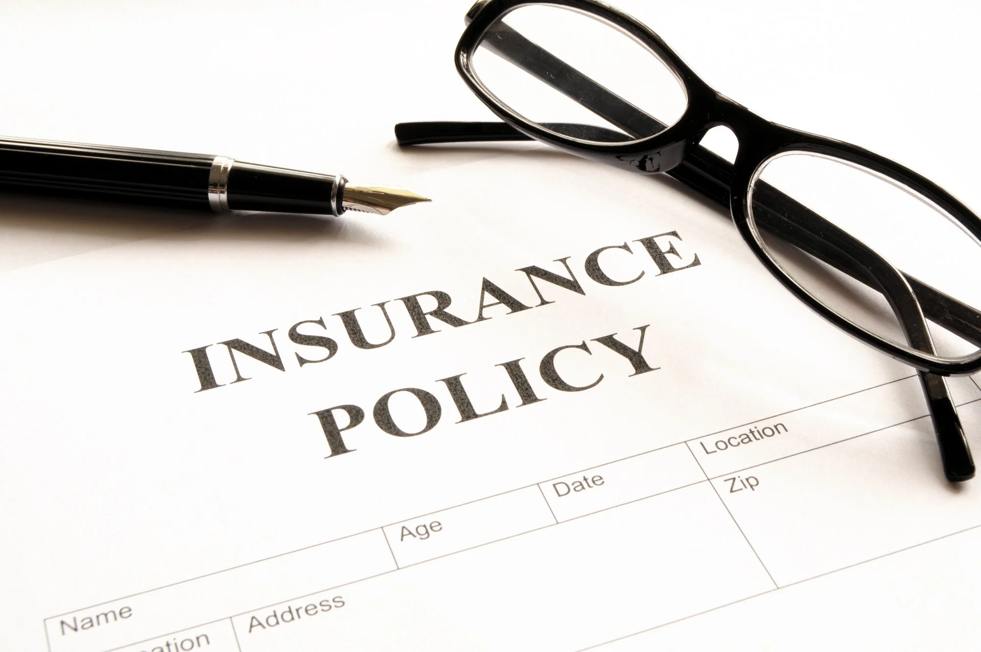 insurance policy paper with glasses and pen
