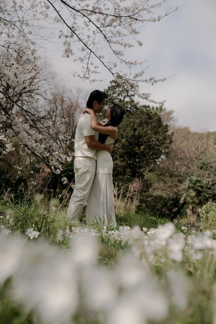 Couple embracing after proposal, cherry blossom garden Tokyo