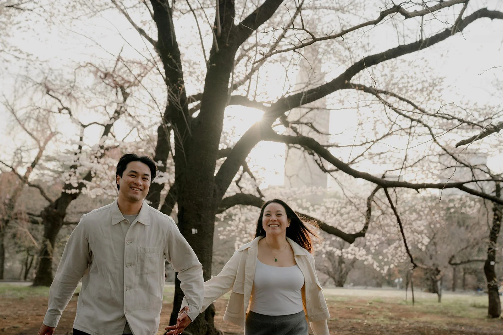 Couples photoshoot under cherry blossoms in Shinjuku Gyoen, Tokyo, spring afternoon