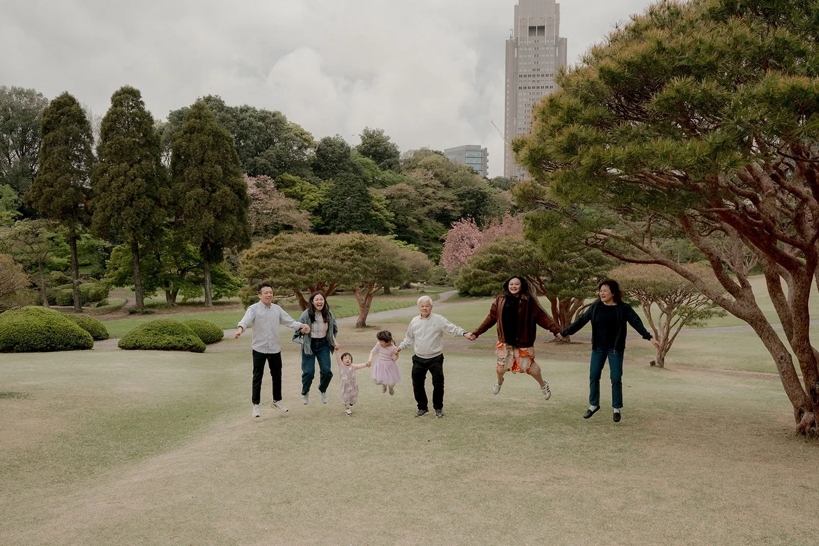 Candid family walk along the cherry blossom path at Shinjuku Gyoen