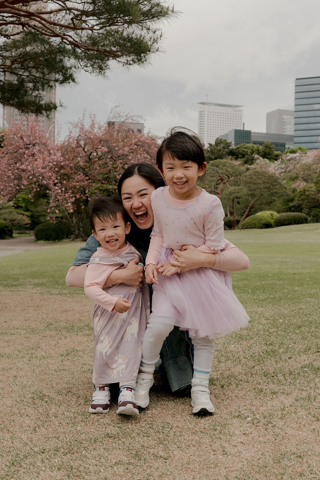 Children spinning under cherry blossoms, family photoshoot Shinjuku Gyoen