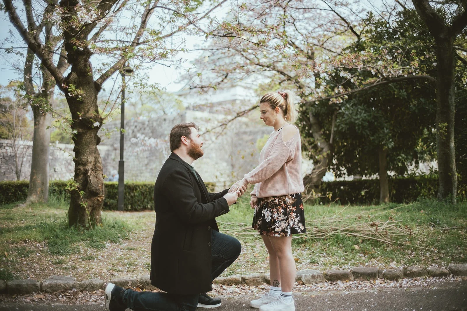 Proposal photoshoot at Osaka Castle with cherry blossoms at sunset