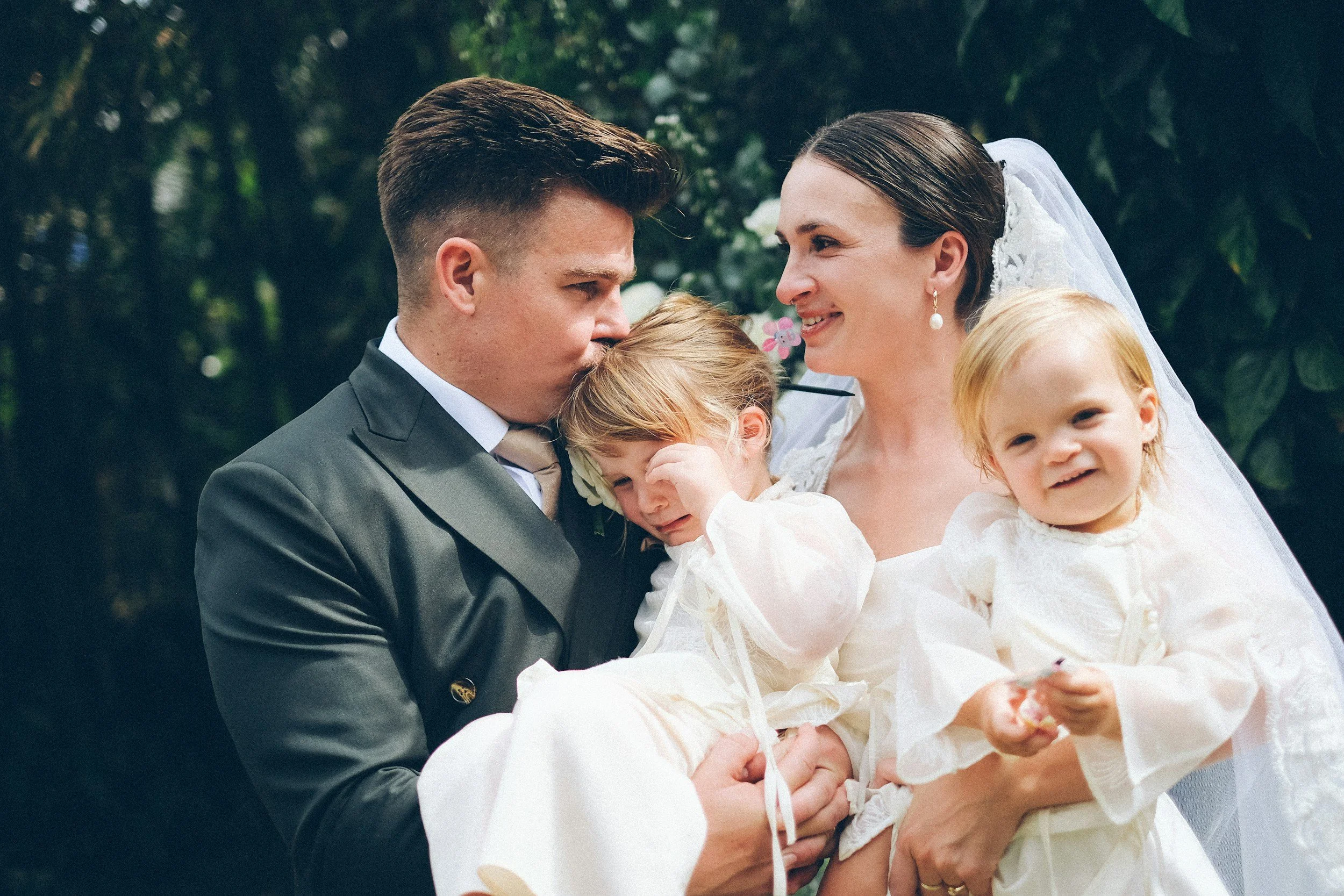 Bride and groom holding their chidlren during a marriage ceremony