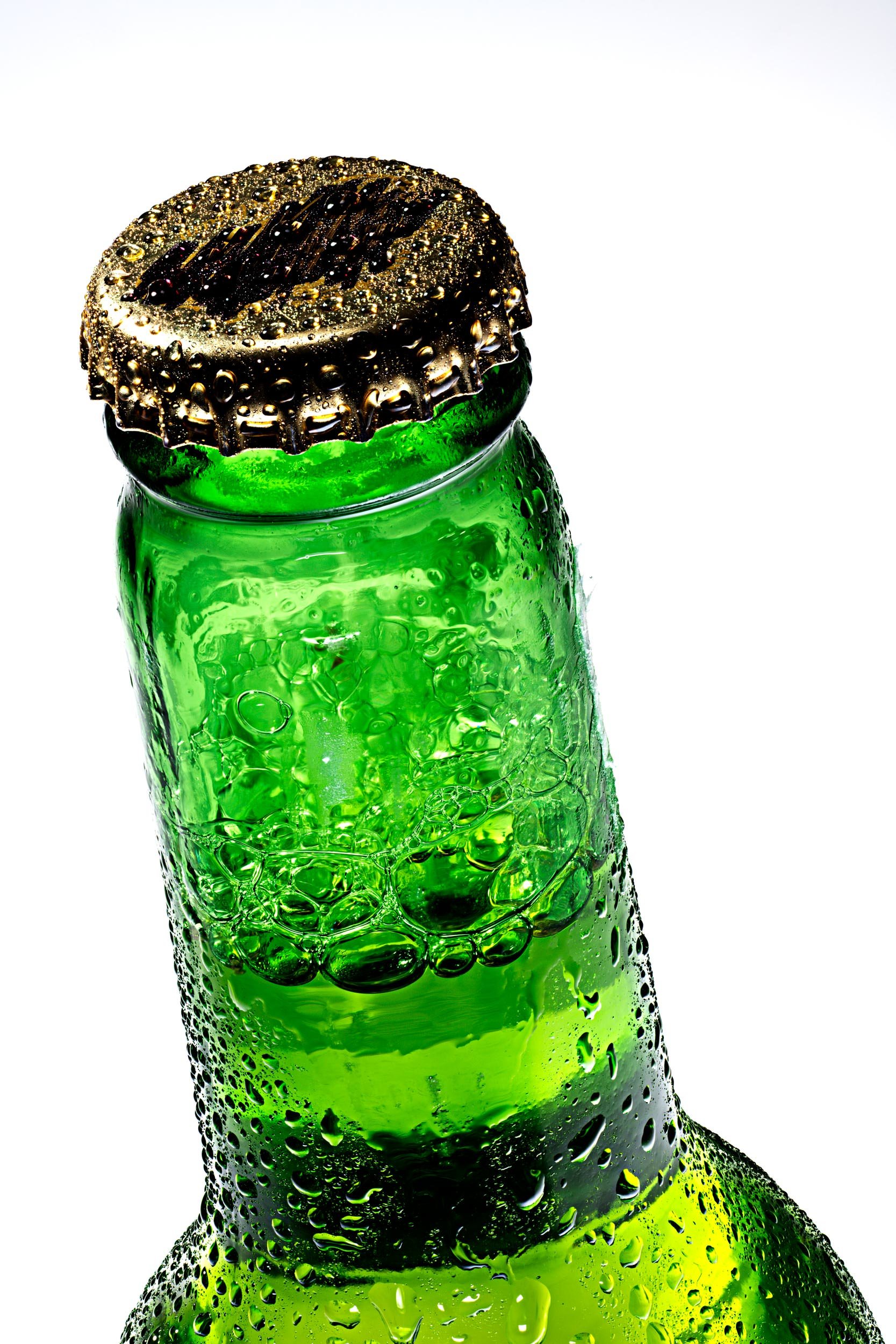 Tilted close-up of green beer bottle cap with condensation