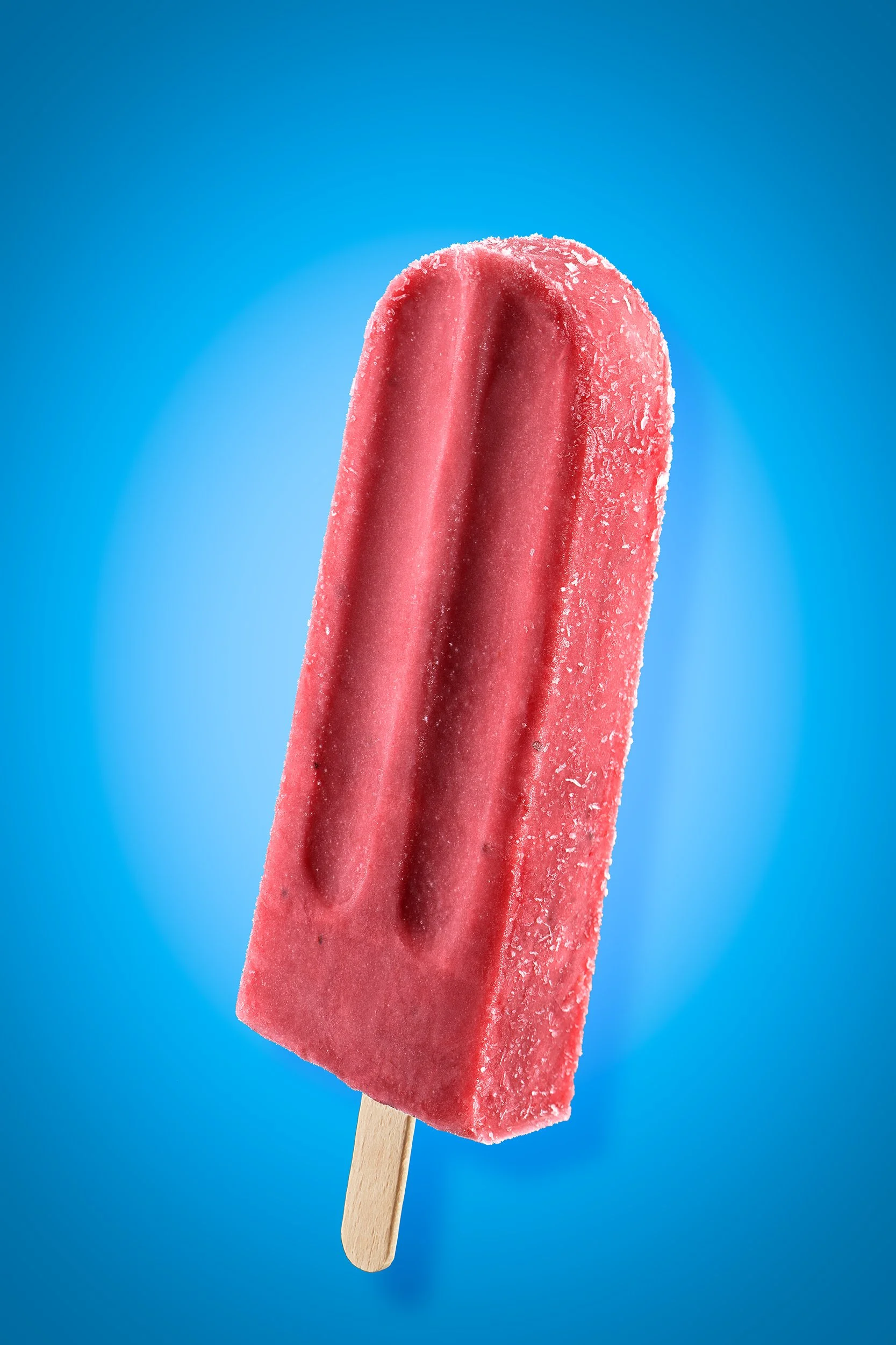 Quartier Général Red fruit popsicle with frosty surface on bright cyan background