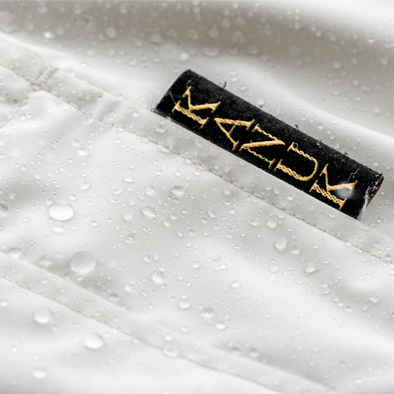 White Kanuk winter parka repelling water droplets in studio, product photographer Montreal 