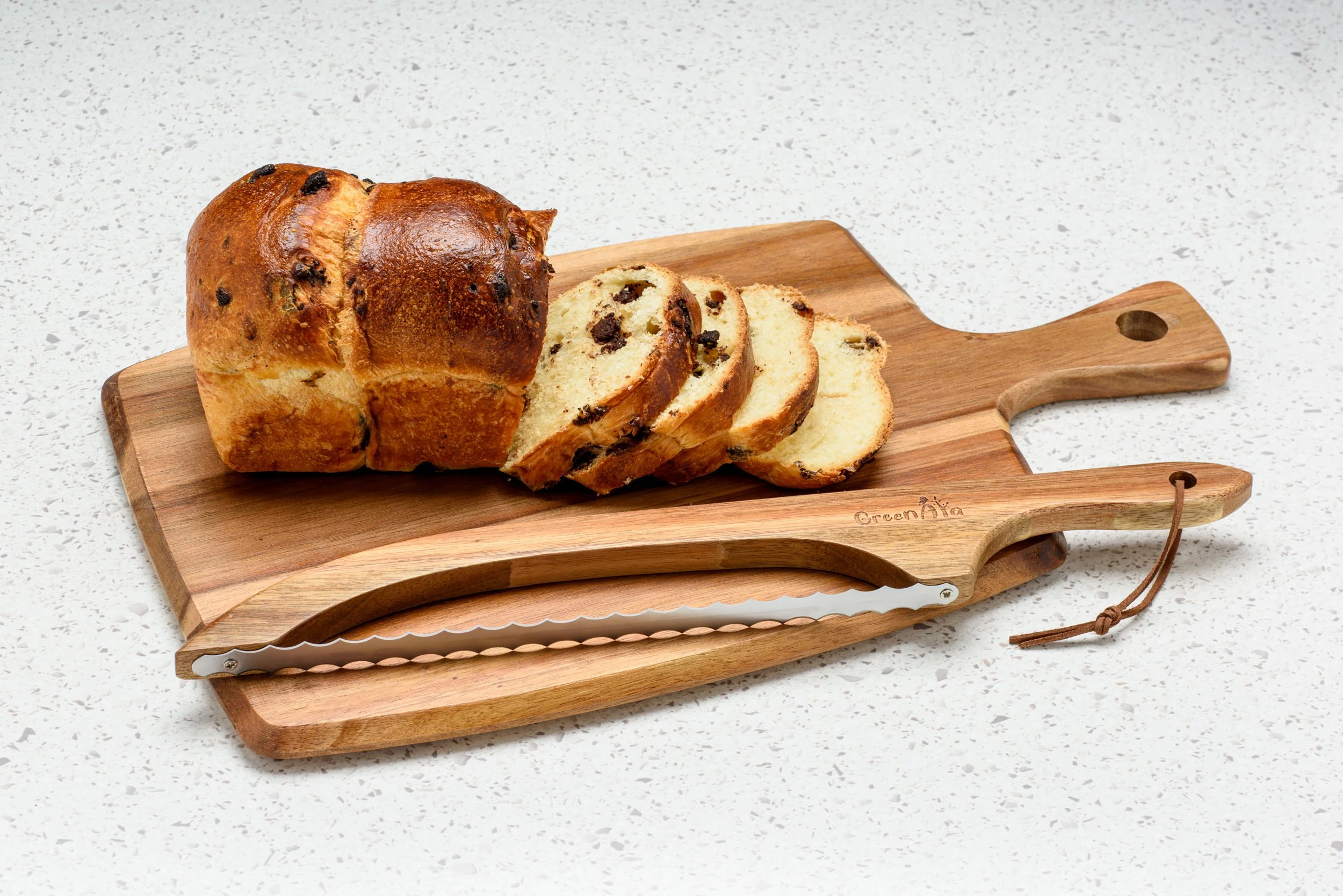Bread knife resting on a board next to a sliced loaf of chocolate chip bread