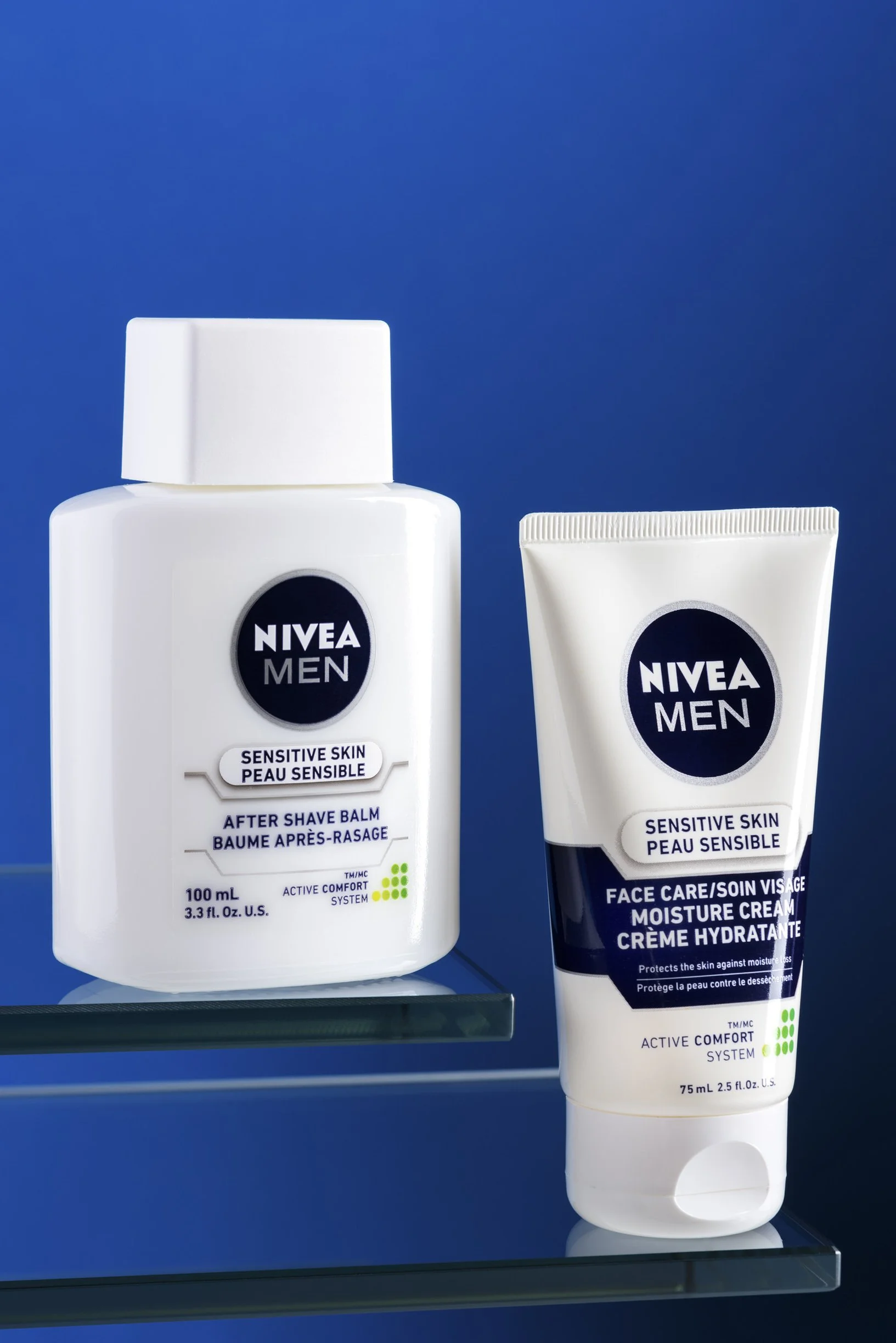 Nivea aftershave balm and moisturizer for men shown on glass shelves with blue backdrop