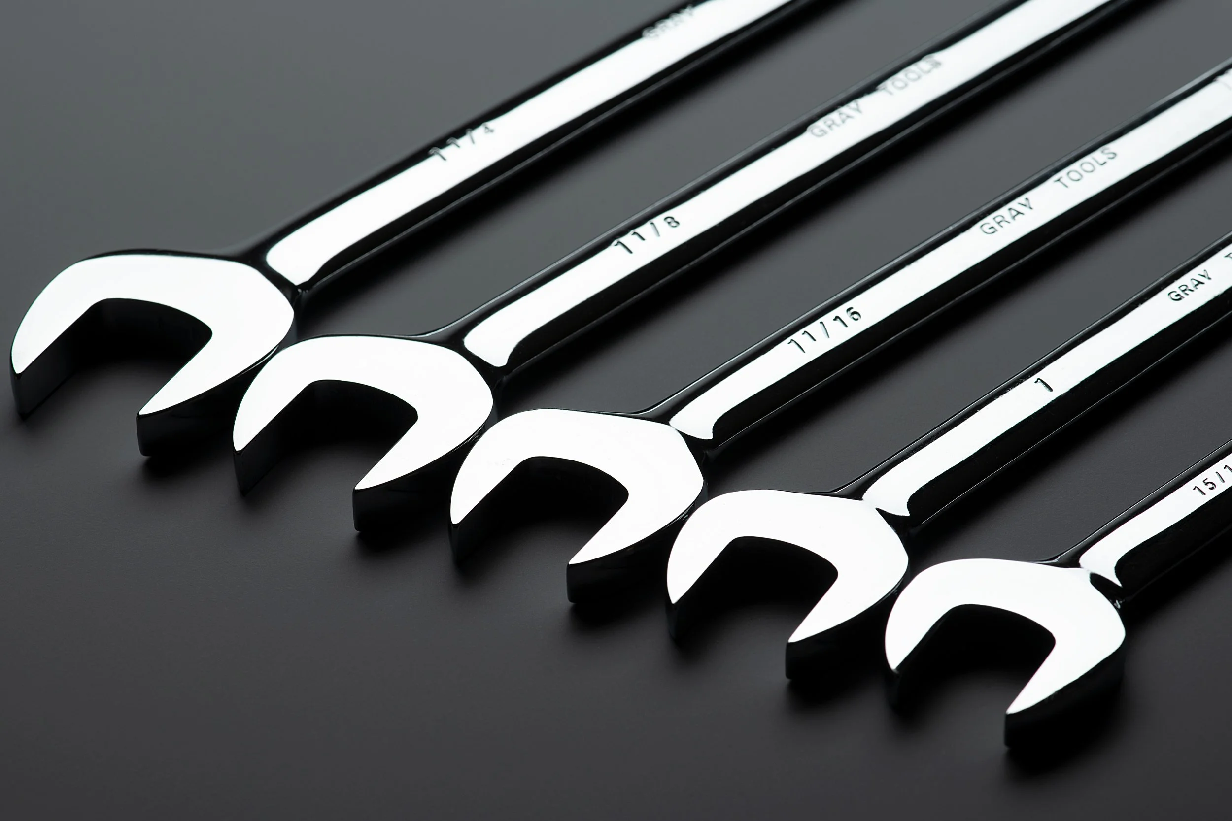 Gray Tools open-end wrenches on black surface