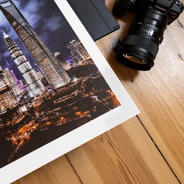 Photo print of a city skyline at night beside a camera