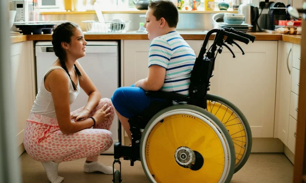 sister-helping-her-disabled-brother-in-the-kitchen