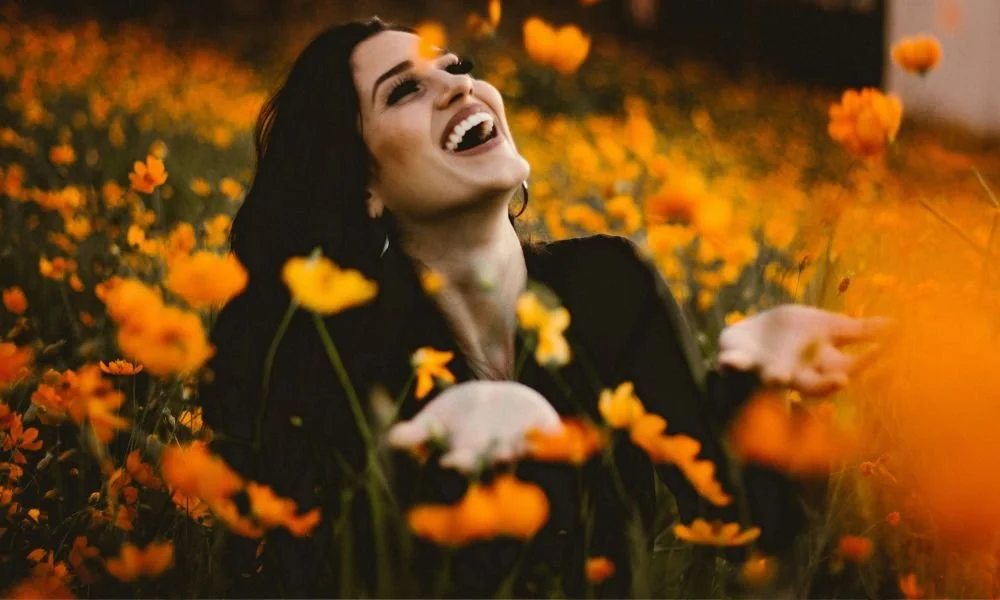 woman-laughing-on-flower-field
