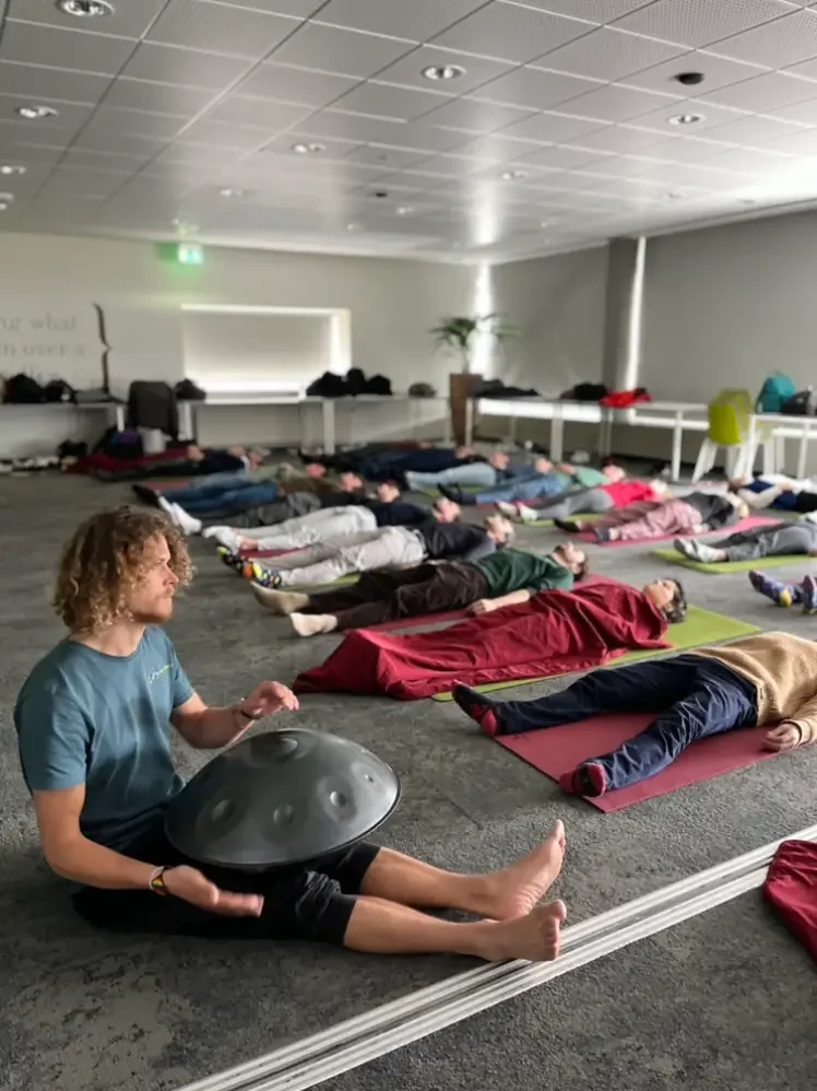 Group breathing session in a room with Tjeerd playing a handpan.