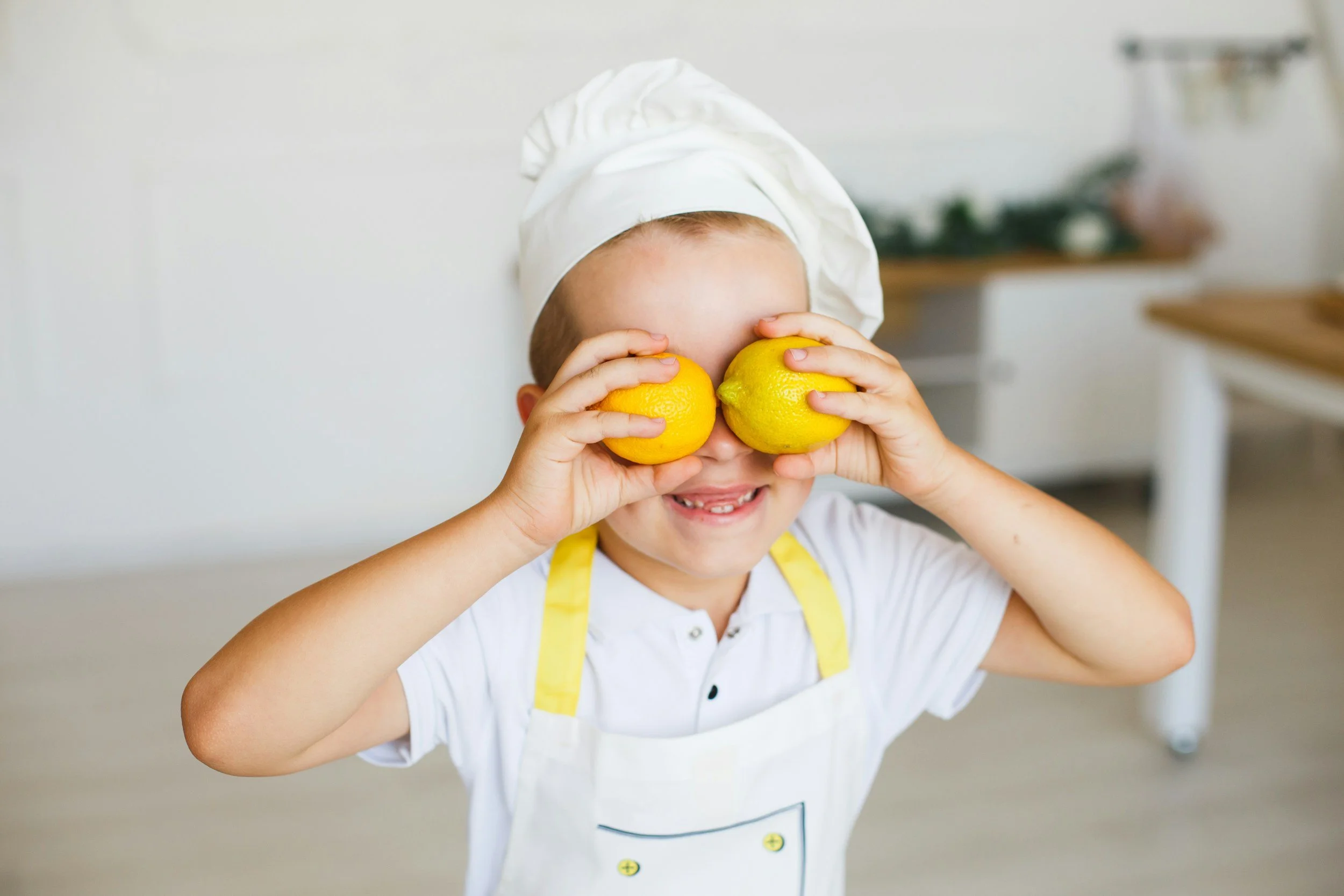 Child wearing a chef hat during a Say Grace Children's Culinary Academy cooking class.