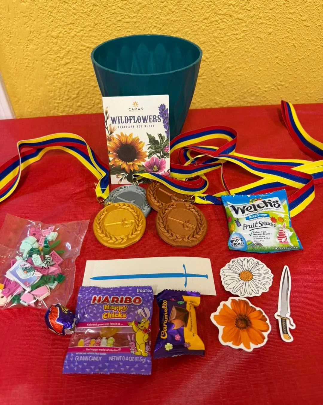 Awards and medals are ready for our tournament this weekend! We leaned into the spring theme.

Each top four finisher gets a medal and a prize bag. First place gets a flowerpot and a blue sword vinyl decal; everything else shown goes to all winners (