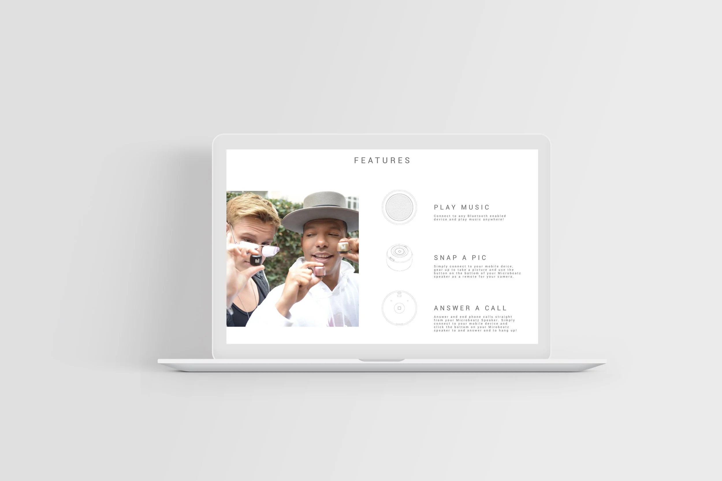 Laptop screen displaying features of a miniature Bluetooth speaker, including options to play music, snap a picture, and answer a call, with a photo of two young men using the device.