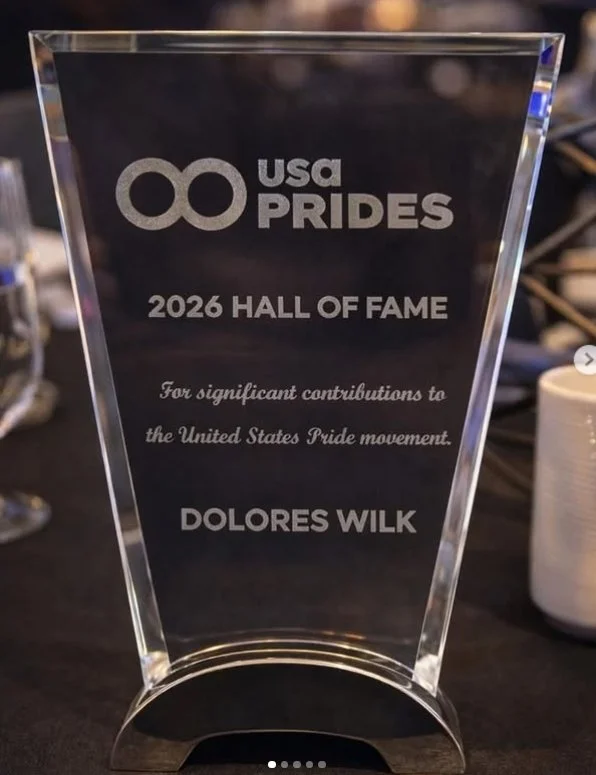 A clear glass award with the USA Pride logo at the top, inscribed with '2026 Hall of Fame', recognizing Dolores Wilk for significant contributions to the United States Pride movement.