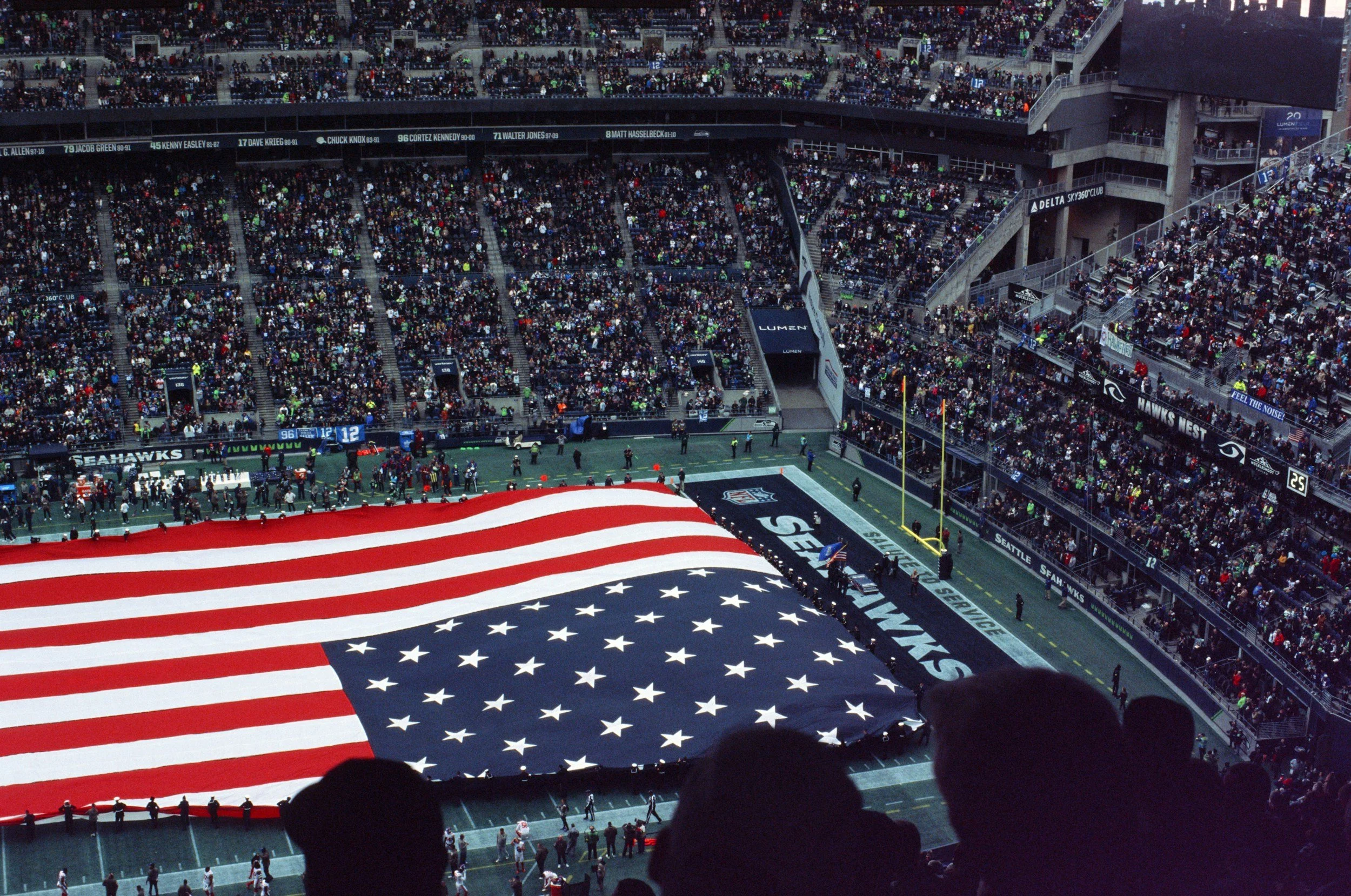 Seattle Seahawks football field with American flag displayed at center and a packed stadium of fans, capturing the excitement of a live NFL game