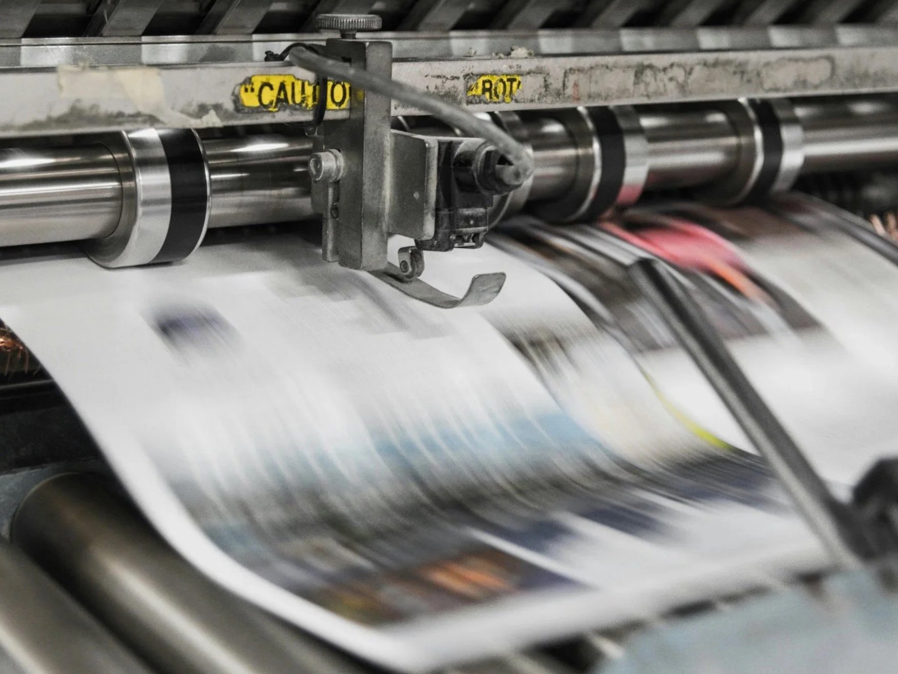Close-up of freshly printed newspapers in a printing factory, highlighting the production process and mass printing of news media.