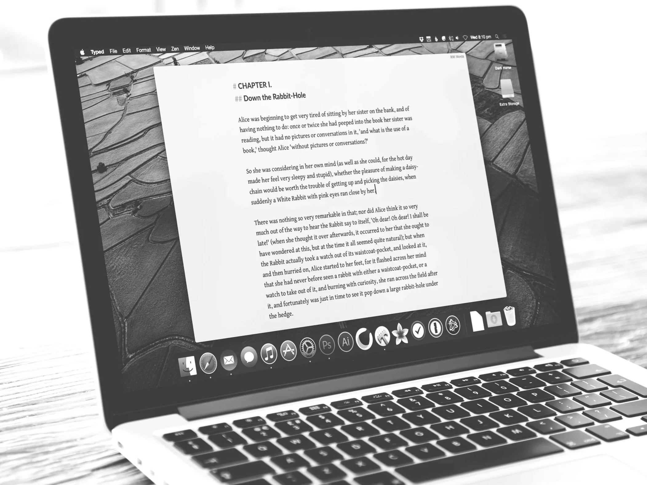 Black and white image of a laptop on a desk, symbolizing post-production work, digital editing, and media management in a filmmaking workflow.