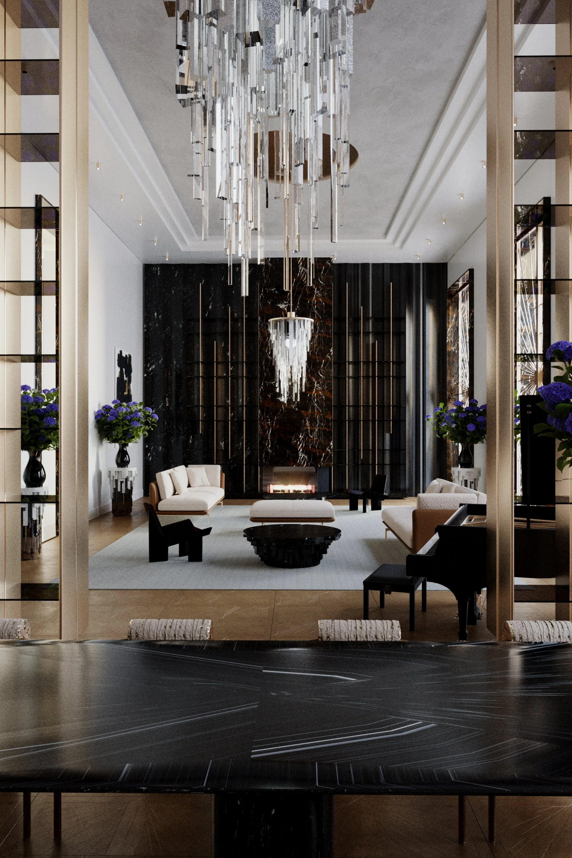 Une salle de séjour élégante avec un mobilier moderne, un grand chandelier suspendu, un mur en marbre noir avec cheminée, des fleurs violettes dans des vases, et une vue partielle d'une table en bois.
