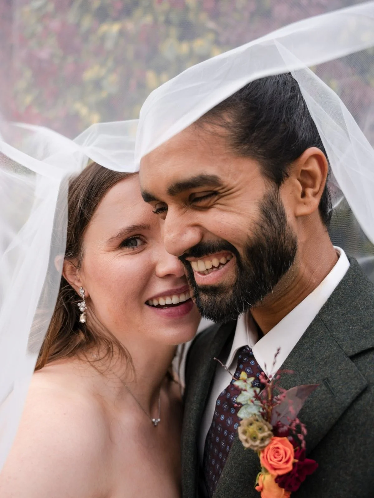 Bride and groom laughing cheek to cheek under her veil at their wedding in Ireland