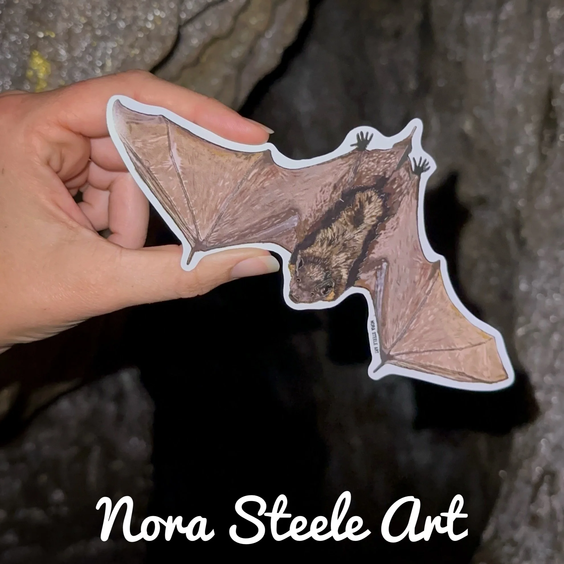 Little brown bat sticker flying in front of a tree at night