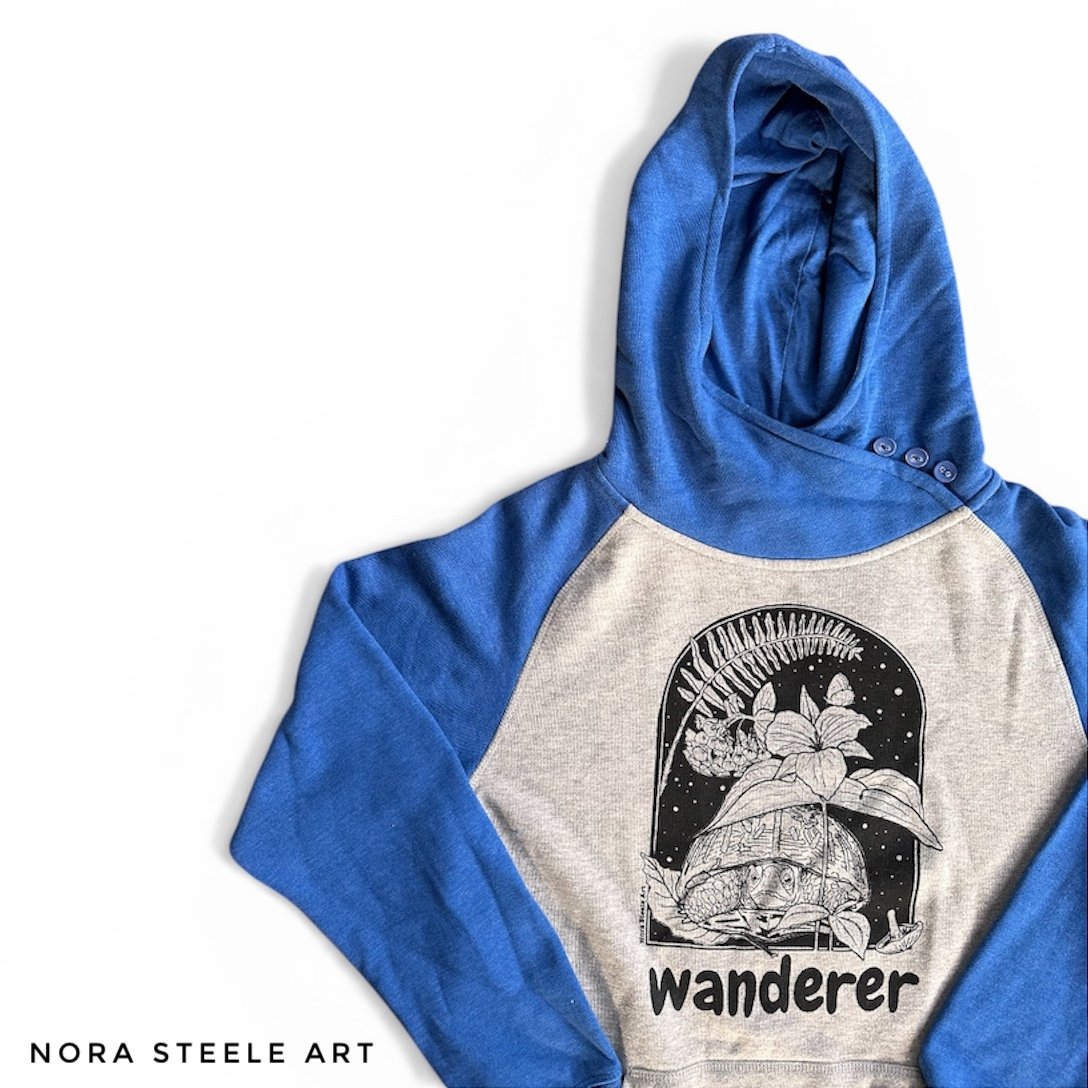 Hoodie screenprinted with a box turtle, trillium, fern, and bluebells with text saying "wanderer"
