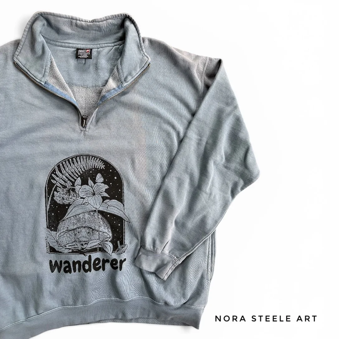 Sweatshirt screenprinted with a box turtle, trillium, fern, and bluebells with text saying "wanderer"
