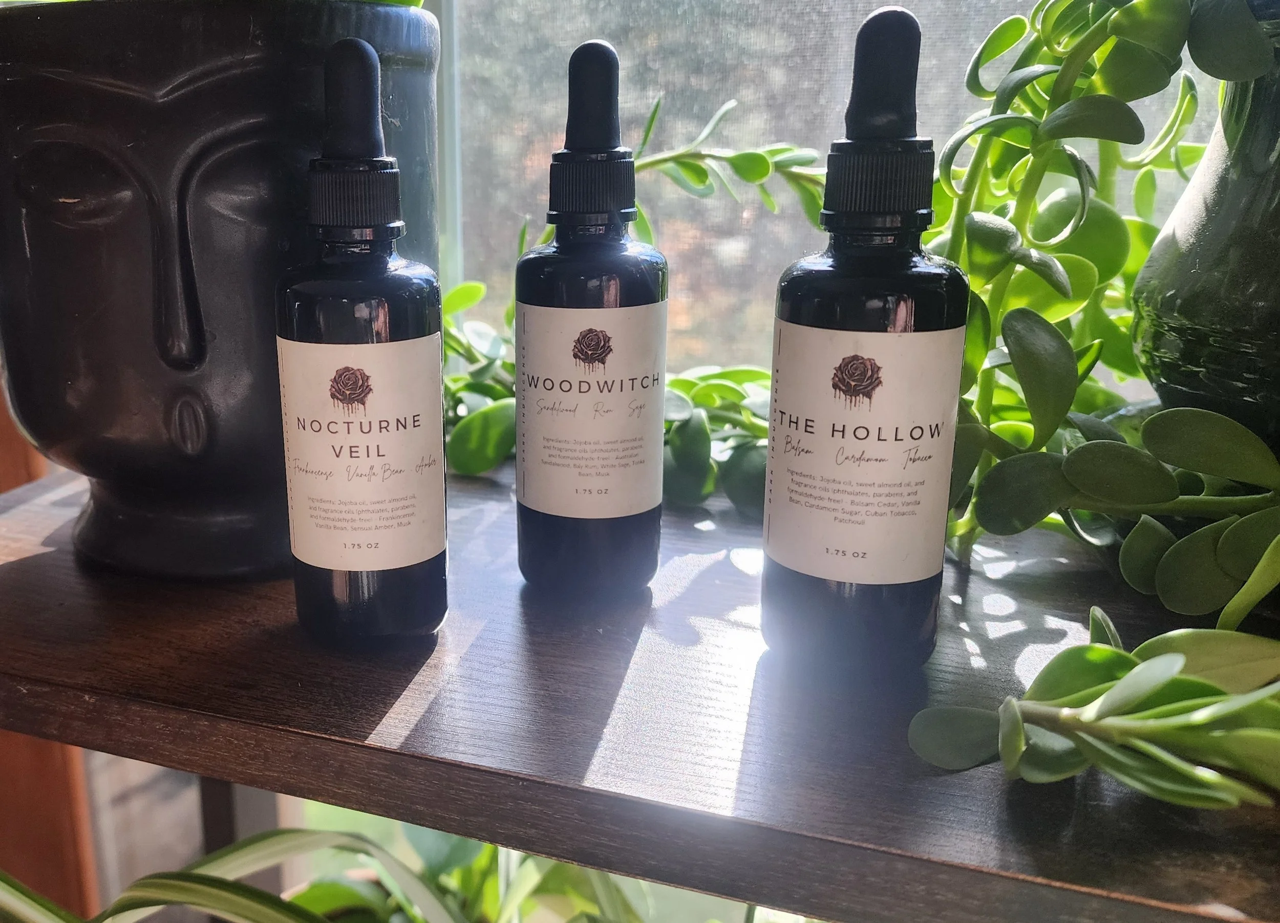 perfume oils on plant shelf.jpg