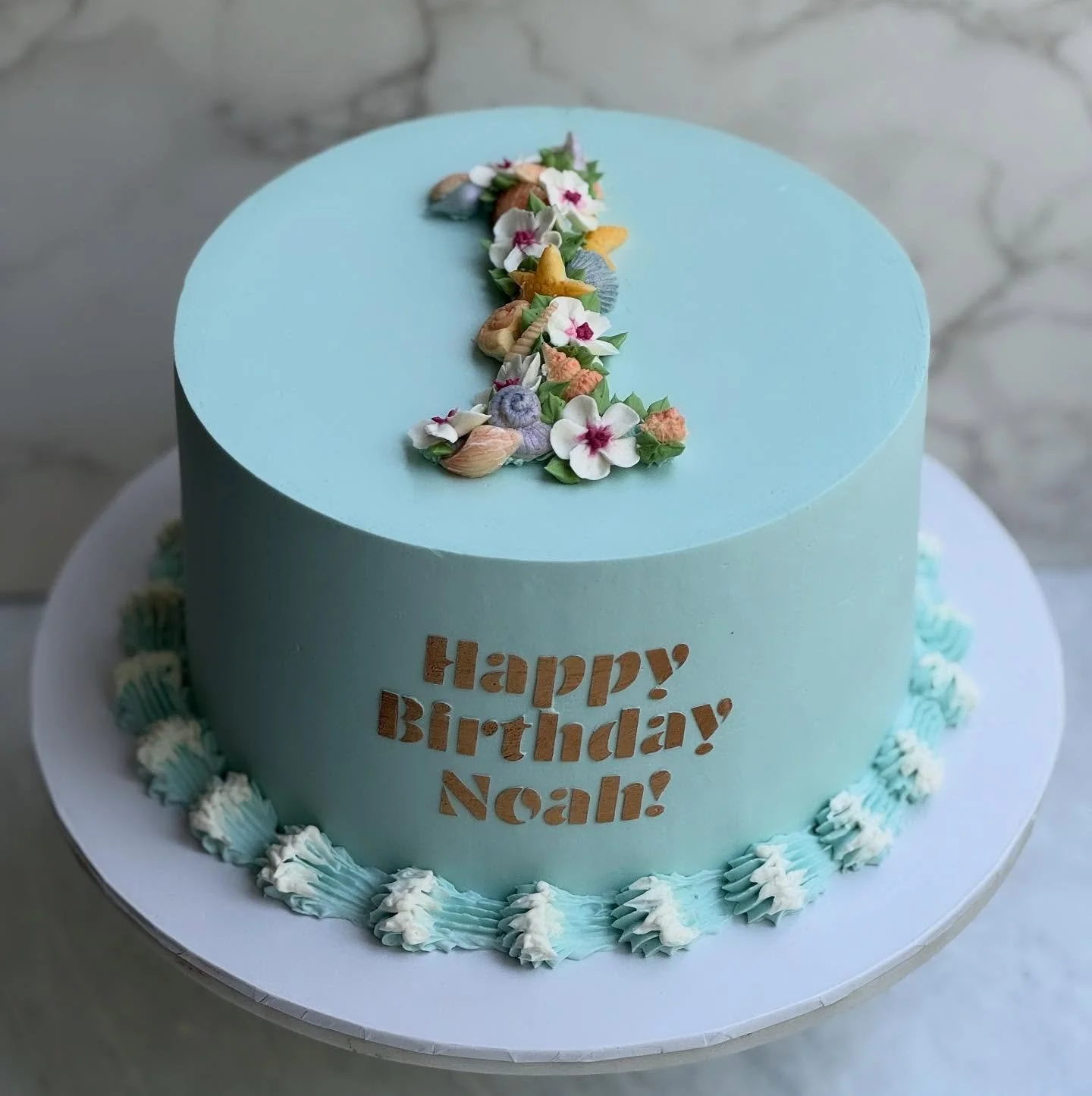 An ocean-themed first birthday for Noah 🌊

Confetti cake, strawberry buttercream,  buttercream flowers, chocolate shells