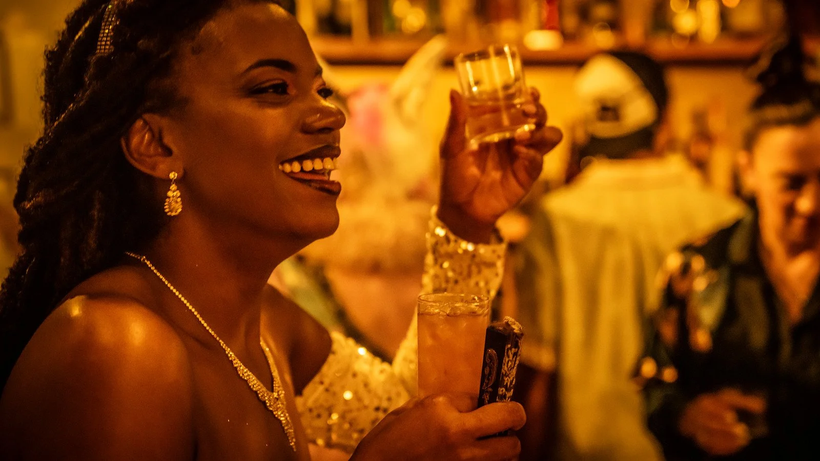 Smiling guest raising a cocktail at Marriott's pop-up bar at The Ritz-Carlton, New Orleans during Tales of the Cocktail