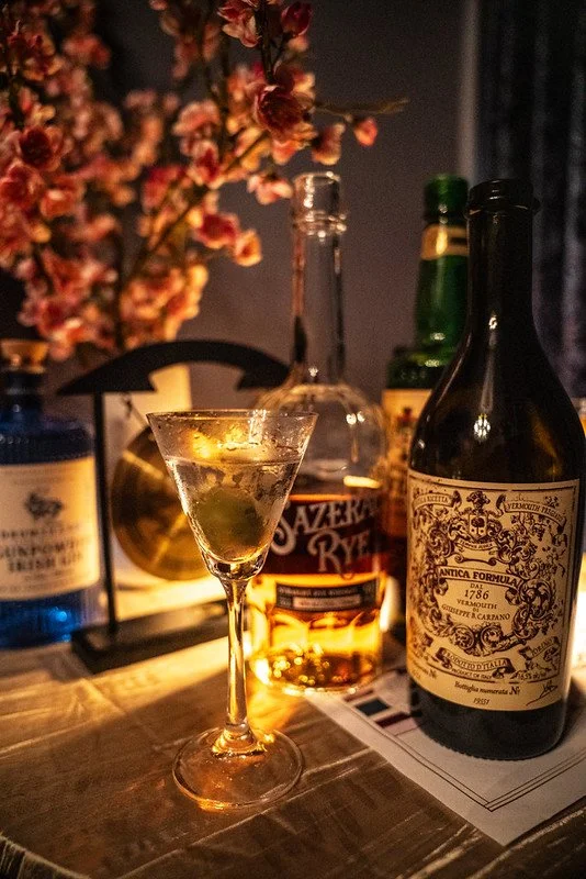 Spirit bottles and a cocktail under cherry blossoms at Marriott's Tales of the Cocktail pop-up