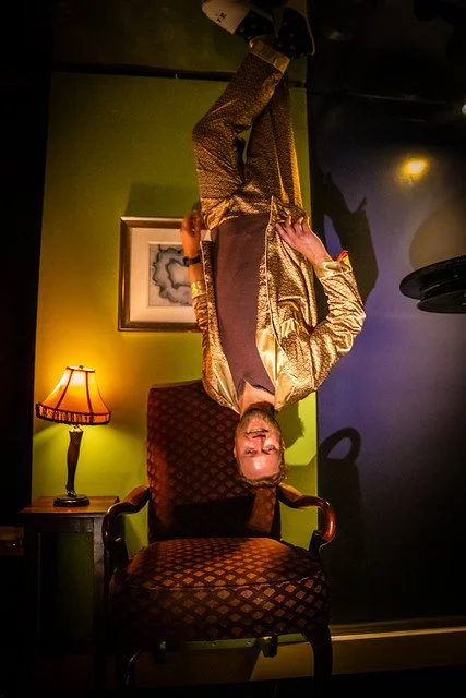 Aerialist hanging upside down in a moody lounge at Marriott's Tales of the Cocktail pop-up