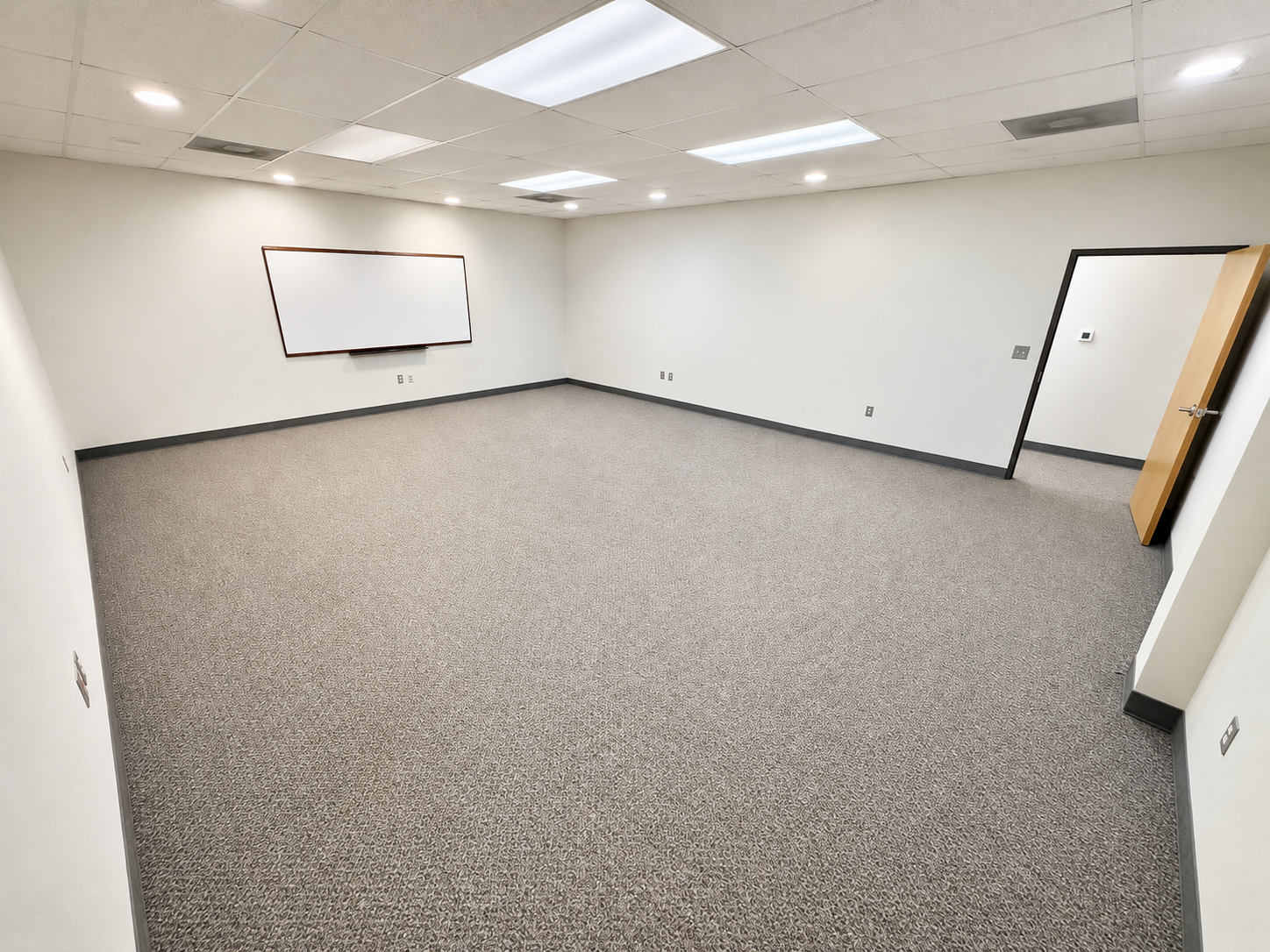 Spacious open office with carpeted flooring, white walls, and overhead lighting at 2462 Long Avenue in Fort Worth, Texas.