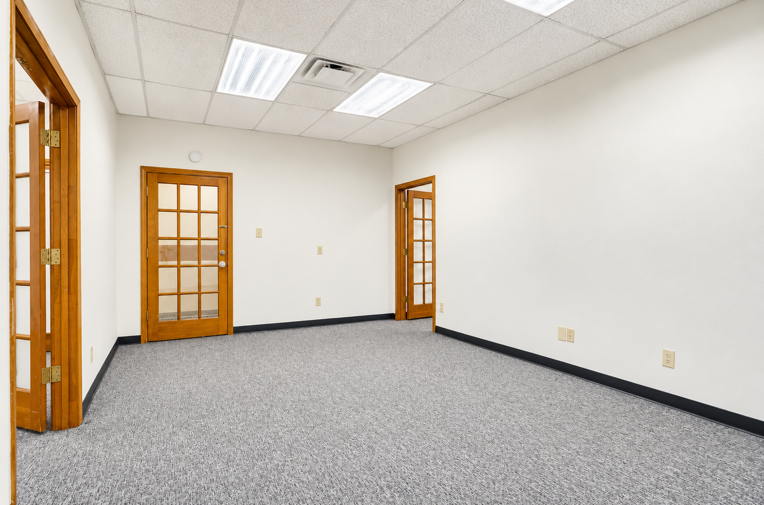Unfurnished private office with carpet, overhead lighting, and wooden-framed glass doors at 405 Airport Freeway in Bedford, Texas.