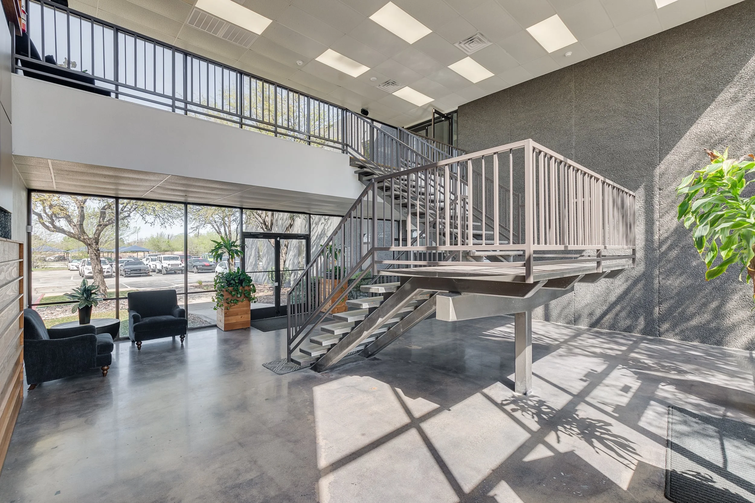 Spacious office building lobby with glass entrance, staircase, and natural light at 4925 Davis Boulevard in North Richland Hills, Texas.