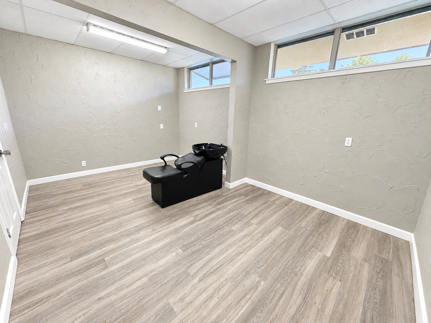 Private office with wood-look flooring, neutral walls, and natural light from a window at 112 W. Pipeline Road in Hurst, Texas.