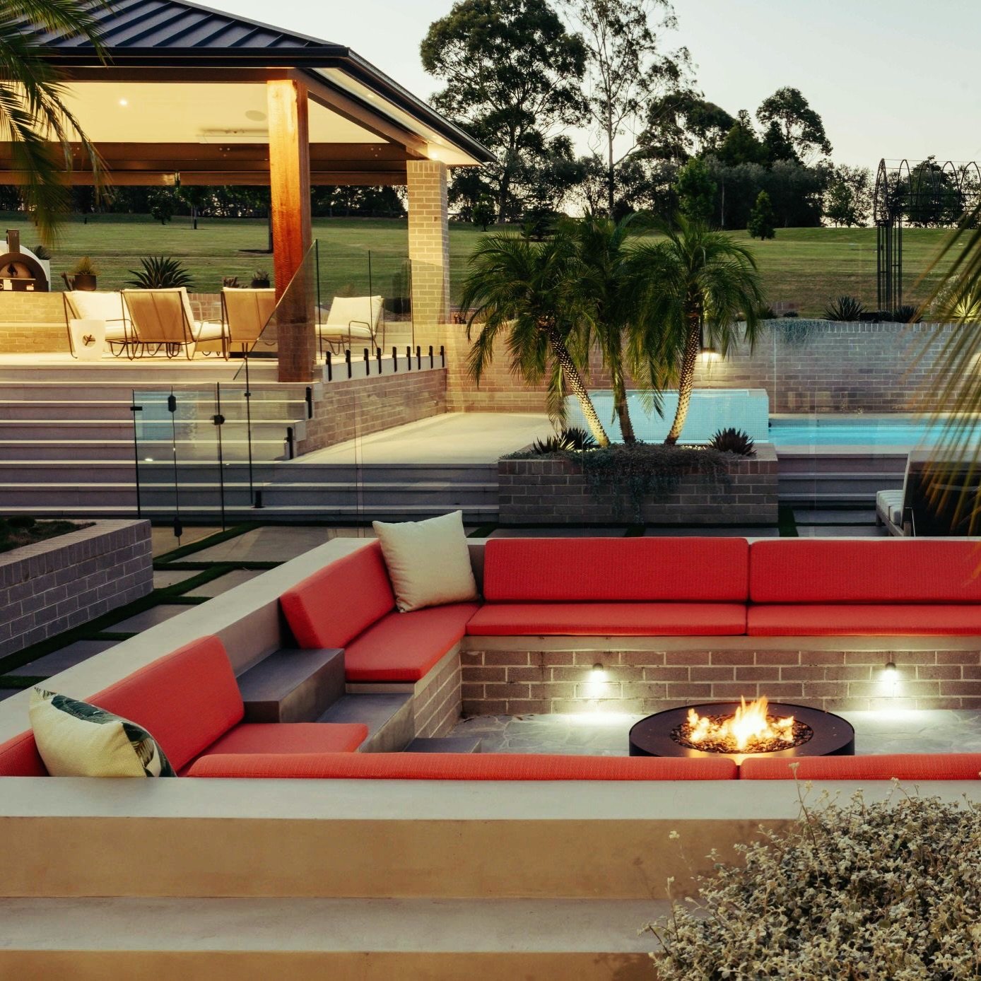 This is what outdoor living is all about ✨
A luxury sunken firepit nestled beside a bespoke pool and pool house, with a fully equipped outdoor kitchen ready for effortless entertaining.

Designed by @fluidlandscapedesign 
Construction by @invision_ho