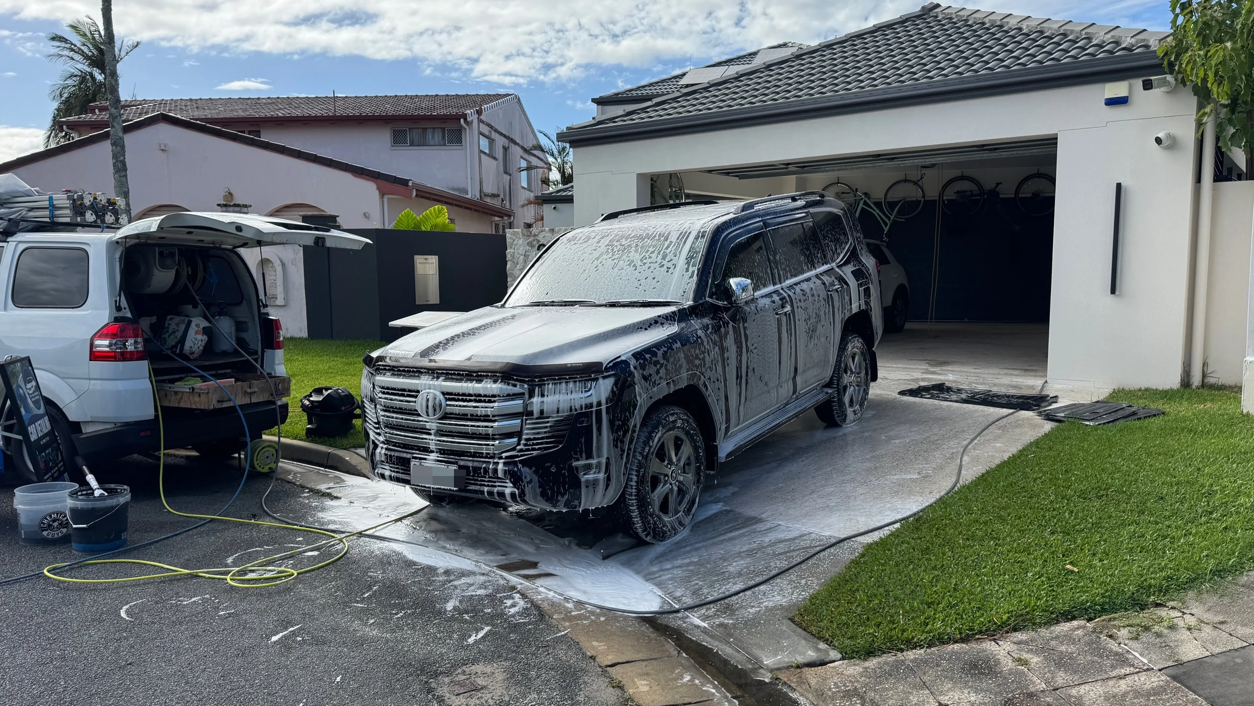 The Auto Detailers are working on a blue Toyota Land Cruiser covered in snow foam after receiving a mobile car detail on the Gold Coast.