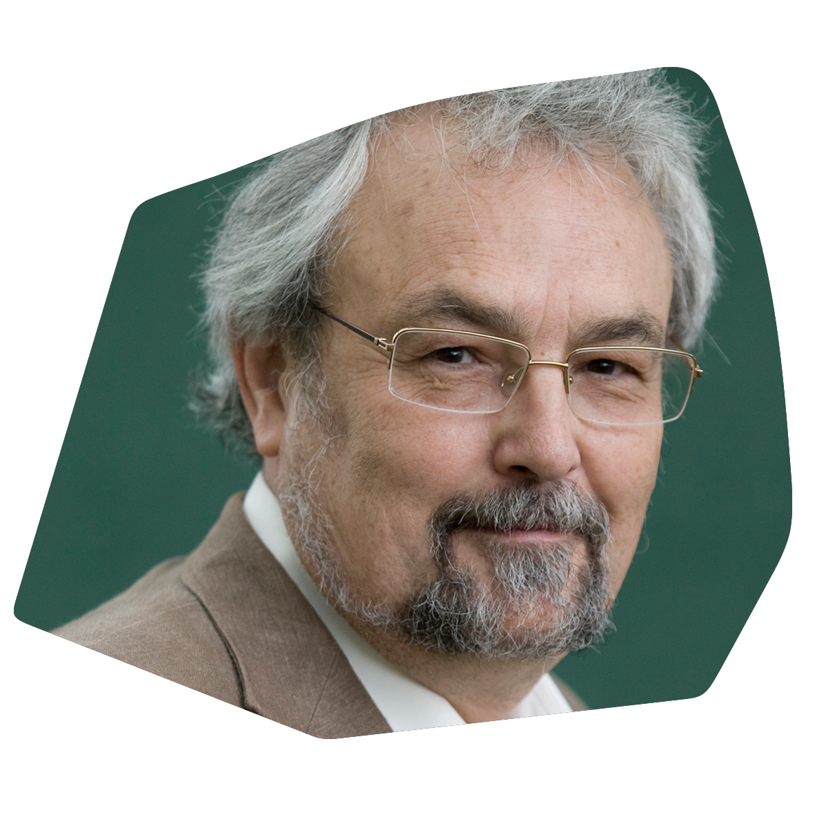 A close-up portrait of an older man with gray hair, glasses, and a beard, smiling slightly, with a green background.
