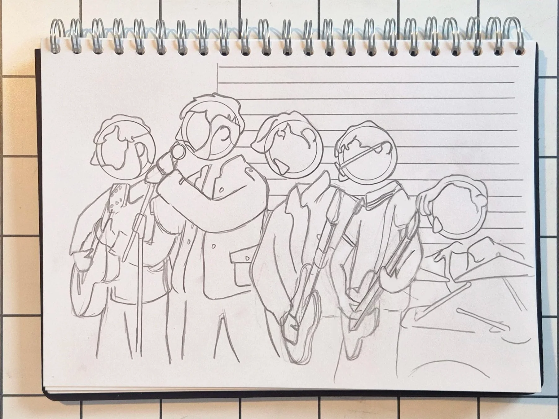 Sketch of a group of five young people in a band, smiling and interacting, drawn on a spiral notebook with lined pages.